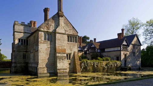 View across the moat towards the Gatehouse and Entrance Range to the left, and the north side of the Courtyard at Baddesley Clinton, Warwickshire